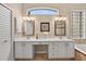 Bright bathroom featuring a double vanity, framed mirrors, and a tiled backsplash at 26111 Feathersound Dr, Punta Gorda, FL 33955