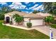 Charming home featuring a well-maintained lawn, tile roof, and attached two-car garage at 26111 Feathersound Dr, Punta Gorda, FL 33955