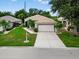 Beautiful single-story home with a well-kept lawn and a concrete driveway leading to a two-car garage at 26111 Feathersound Dr, Punta Gorda, FL 33955
