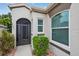 Charming front entry with lush landscaping and a modern glass storm door at 26111 Feathersound Dr, Punta Gorda, FL 33955