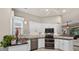 Modern kitchen featuring white cabinetry, stainless steel appliances, and dark granite countertops at 26111 Feathersound Dr, Punta Gorda, FL 33955