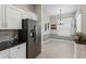 Open kitchen area with stainless steel refrigerator, white cabinets, and adjacent dining space at 26111 Feathersound Dr, Punta Gorda, FL 33955