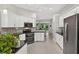 Stylish kitchen with granite counters, stainless steel appliances, and seamless flow to the living area at 26111 Feathersound Dr, Punta Gorda, FL 33955