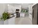 A modern kitchen with stainless steel appliances, white cabinetry, and granite countertops at 26111 Feathersound Dr, Punta Gorda, FL 33955