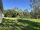 Home's backyard featuring spacious lawn extending back to the tree line at 27128 Aloha Dr, Punta Gorda, FL 33955