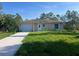 Charming single-story home with a well-manicured lawn and a concrete driveway at 27128 Aloha Dr, Punta Gorda, FL 33955