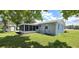 Side view shows a cozy screened-in porch and a spacious backyard with lush green grass and nice landscaping at 2805 Gussie St, Punta Gorda, FL 33950