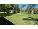 Large grassy backyard featuring mature trees, a storage shed, and plenty of space for outdoor activities at 2805 Gussie St, Punta Gorda, FL 33950