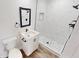 A modern bathroom features a stylish vanity, a framed mirror and a sleek shower stall with patterned floors at 2805 Gussie St, Punta Gorda, FL 33950
