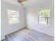 The bedroom features natural lighting from two windows, complemented by wood-look floors and white walls at 2805 Gussie St, Punta Gorda, FL 33950