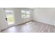 Bright bedroom featuring wood-look flooring and white walls with natural light from a door and window at 2805 Gussie St, Punta Gorda, FL 33950
