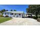 Charming home with manicured lawn, a driveway and a cute porch under a clear blue sky at 2805 Gussie St, Punta Gorda, FL 33950