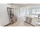 Modern kitchen with stainless steel fridge, white cabinets, and an island with a black faucet at 2805 Gussie St, Punta Gorda, FL 33950