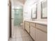 Bright bathroom with tile flooring featuring a double sink vanity, tiled walls, and walk in shower at 3256 White Ibis Ct # 24A, Punta Gorda, FL 33950