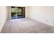 Bright bedroom featuring a large glass sliding door leading to an outdoor patio area overlooking a lake at 3256 White Ibis Ct # 24A, Punta Gorda, FL 33950