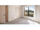 This bedroom features neutral carpeting, white walls, closet with folding doors, and a sunny window at 3256 White Ibis Ct # 24A, Punta Gorda, FL 33950