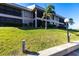 Beautifully landscaped condo building with lush green lawn and mature palm trees at 3256 White Ibis Ct # 24A, Punta Gorda, FL 33950