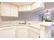 A well-lit kitchen with sleek white appliances and breakfast bar area at 3256 White Ibis Ct # 24A, Punta Gorda, FL 33950