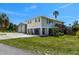 Exterior of a two story home with a detached garage and large driveway at 3616 Allapatchee Dr, Punta Gorda, FL 33950