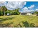 A spacious grassy backyard with mature trees and a screened-in patio at 4044 S Salford Blvd, North Port, FL 34287