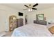 Inviting bedroom featuring a gray dresser, ceiling fan, television, and a peek into the hallway at 4044 S Salford Blvd, North Port, FL 34287