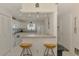 Bright kitchen with all white appliances, tiled flooring and breakfast bar seating two at 4044 S Salford Blvd, North Port, FL 34287