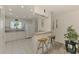 Bright kitchen featuring white cabinetry, appliances, breakfast bar, tile floor, and neutral paint at 4044 S Salford Blvd, North Port, FL 34287