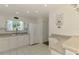 Bright kitchen featuring white cabinetry, appliances, countertops, and a window for natural light at 4044 S Salford Blvd, North Port, FL 34287