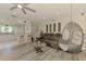 Spacious living room with wood-look floors, hanging chair, comfortable sofa, and an open layout at 4044 S Salford Blvd, North Port, FL 34287