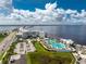 Stunning aerial view of a luxury resort with multiple pools, palm trees, and waterfront access overlooking the tranquil bay at 4089 Yucatan Cir, Port Charlotte, FL 33948