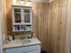Neutral bathroom offering a vanity with sink, medicine cabinet, and wood paneled walls at 4089 Yucatan Cir, Port Charlotte, FL 33948
