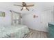 Bedroom with modern ceiling fan, wood laminate flooring, and beach-themed decor at 4089 Yucatan Cir, Port Charlotte, FL 33948