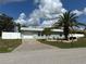 Charming home with a well-manicured front yard, a white fence, and an attached garage at 4089 Yucatan Cir, Port Charlotte, FL 33948
