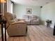 Comfortable living room featuring reclining sofa set and wood-look flooring at 4089 Yucatan Cir, Port Charlotte, FL 33948