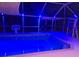 In-ground pool in screened lanai at night with accent lighting at 4089 Yucatan Cir, Port Charlotte, FL 33948