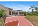 Charming brick patio area leading to a screened-in pool overlooking lush greenery and a canal at 4317 Mccullough St, Port Charlotte, FL 33948