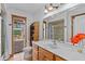 Bright bathroom with wooden vanity, a wicker shelf and tile floors near shower and toilet at 4317 Mccullough St, Port Charlotte, FL 33948