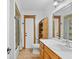 Bright bathroom with wooden vanity, a wicker shelf and tile floors near shower and toilet at 4317 Mccullough St, Port Charlotte, FL 33948