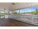 View from screened lanai, showcasing wood flooring, white railing, and overlooking the pool and canal at 4317 Mccullough St, Port Charlotte, FL 33948