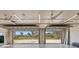 View from inside the spacious garage showing open doors, ceiling fans, and fluorescent lighting at 4317 Mccullough St, Port Charlotte, FL 33948