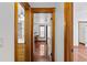 Hallway with wood floors leads to a brightly lit workspace and bathroom at 4317 Mccullough St, Port Charlotte, FL 33948