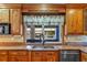 This kitchen features a stainless steel dishwasher, sink, and light colored tile backsplash at 4317 Mccullough St, Port Charlotte, FL 33948
