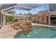 Inviting covered pool with a rock waterfall feature and serene, landscaped surroundings at 4317 Mccullough St, Port Charlotte, FL 33948