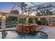 Inviting pool with a rock spa and lush plantings, under a covered screen at 4317 Mccullough St, Port Charlotte, FL 33948