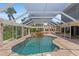 Sparkling pool with waterfall feature under a screened enclosure and beautiful patio at 4317 Mccullough St, Port Charlotte, FL 33948