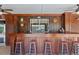 Poolside wooden bar with multiple stools, a service window and ample space for entertaining at 4317 Mccullough St, Port Charlotte, FL 33948