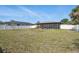 Large backyard featuring a screened-in lanai and a white vinyl fence at 4358 Pates St, Port Charlotte, FL 33948