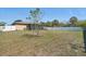 Large backyard with a view of the screened-in patio and surrounding fence at 4358 Pates St, Port Charlotte, FL 33948