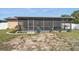 Backyard view featuring a screened-in patio and landscaped area at 4358 Pates St, Port Charlotte, FL 33948