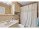 Cozy bathroom with tile walls, a toilet, sink, and shower with curtain at 4358 Pates St, Port Charlotte, FL 33948